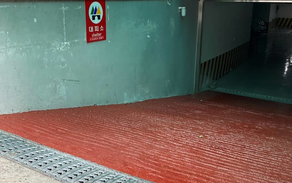 ▲인터뷰에 참여했던 휠체어 사용 시민이 보내준 지역 대피소 입구 사진. 주민센터 지하주차장인 대피소 출입구는 가파른 경사로 이뤄져 있어 조력 없이는 휠체어 접근이 불가능했다. 또한 입구에는 시각장애를 가진 사람들을 위한 점자블럭이 설치되어 있지 않았다. ⓒ 인터뷰 참여자 제공