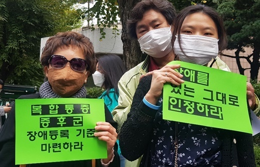 2020년 10월 15일 국민연금공단 장애심사센터 앞 기자회견에서 ‘복합통증증후군 장애등록 기준 마련하라’ 손피켓을 들고 있는 참가자.ⓒ에이블뉴스DB  출처 : 에이블뉴스(https://www.ablenews.co.kr)