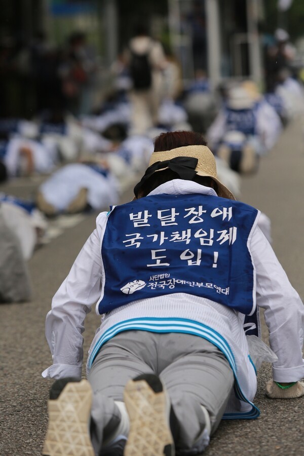 2023년 6월 14일 장애자녀를 둔 부모가 ‘발달장애인 전 생애 지원체계 구축’을 촉구하며 오체투지로 대통령실을 향하고 있다. ©에이블뉴스DB  출처 : 에이블뉴스(https://www.ablenews.co.kr)