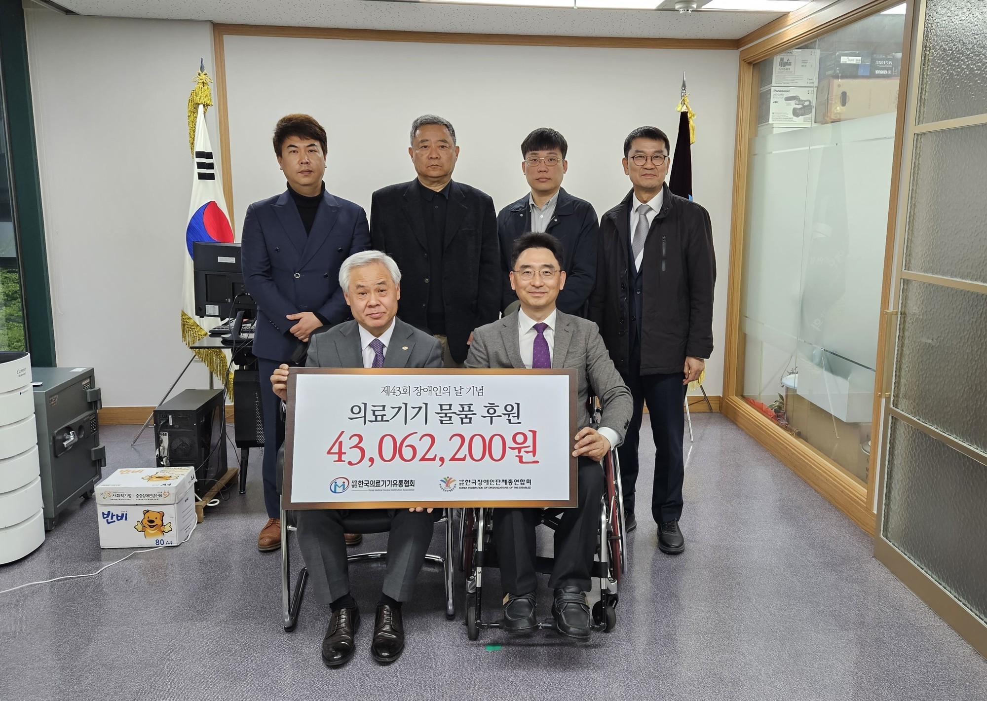 왼쪽으로 부터 한국의료기기유통협회 관계자 5명과 장총련 사무총장이 의료기기물품 기증식 하고 있다@한국장애인단체총연합회