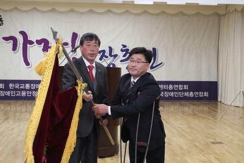 한국장애인단체총연합회 상임대표 이취임식 _안진환 상임대표에게 협회기를 전달하고 있는 김완배 상임대표 @한국장애인단체총연합회
